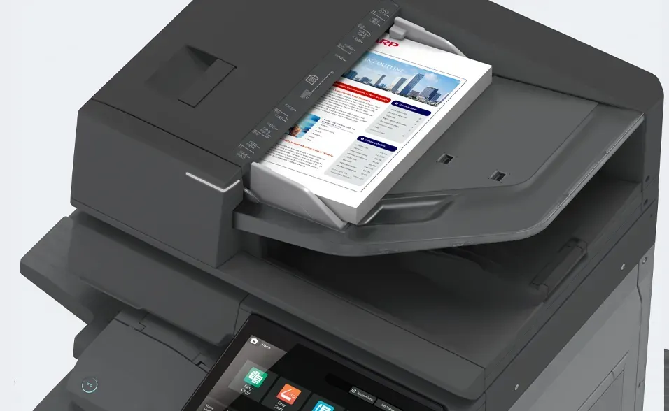 Multifunction printer, black, with a color document in the document feeder. Touchscreen control panel visible.