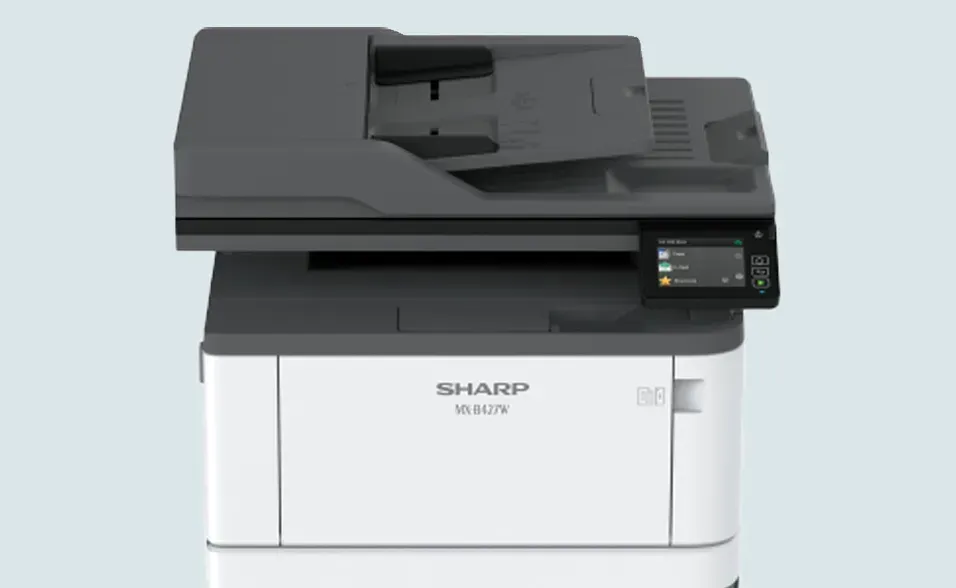 A Sharp multifunction printer, white base with gray top, touch screen control panel.