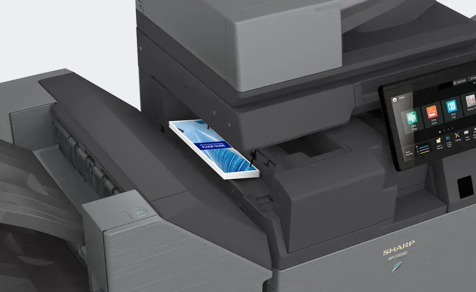 A mobile phone rests on a black and gray office printer.