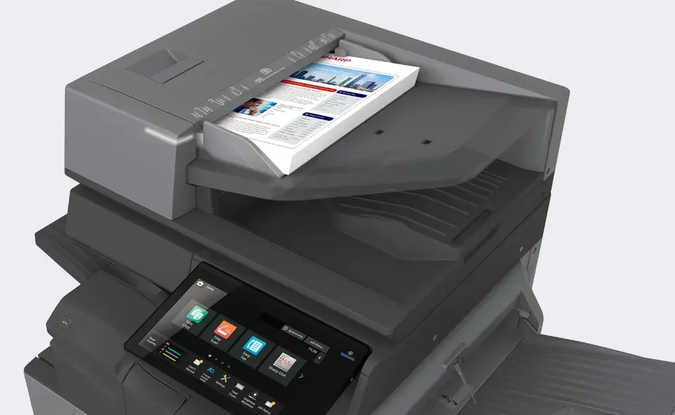 Multifunction printer with documents in the output tray and a touchscreen interface.