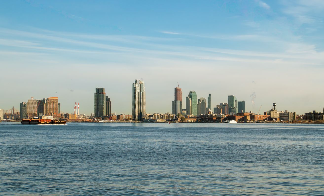 A city skyline is visible over a body of water.