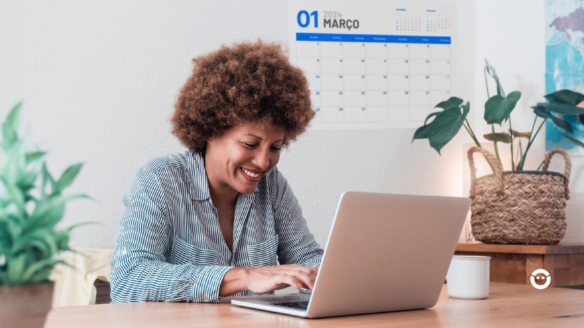 Uma mulher está sentada a uma mesa usando um laptop.