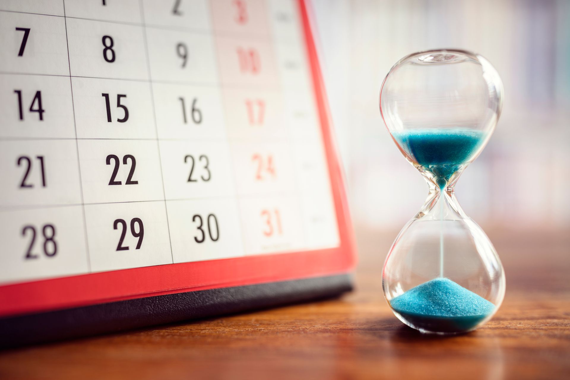 Imagem de um calendário e uma ampulheta com areia caindo