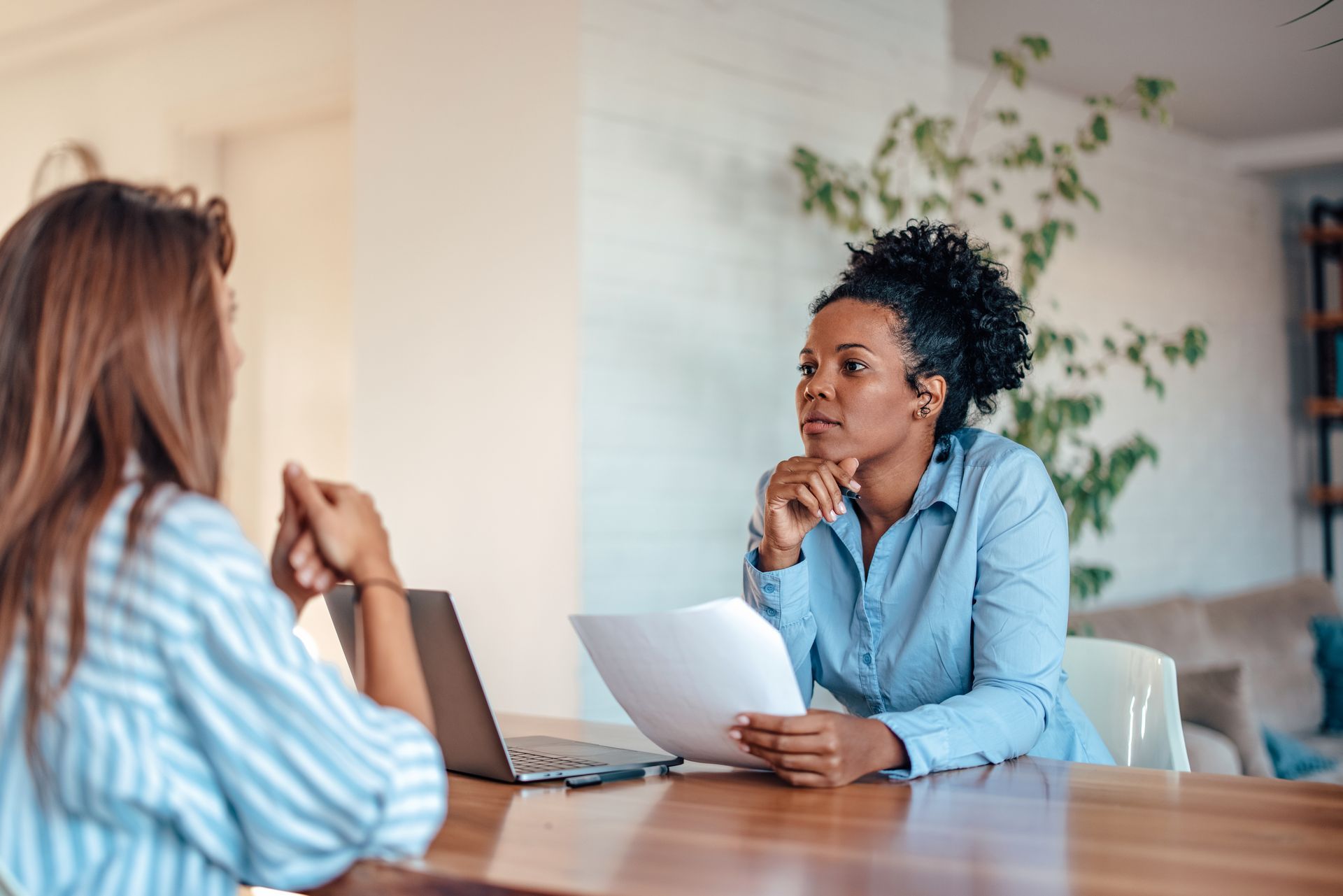 Duas mulheres estão sentadas à mesa para uma entrevista de emprego.