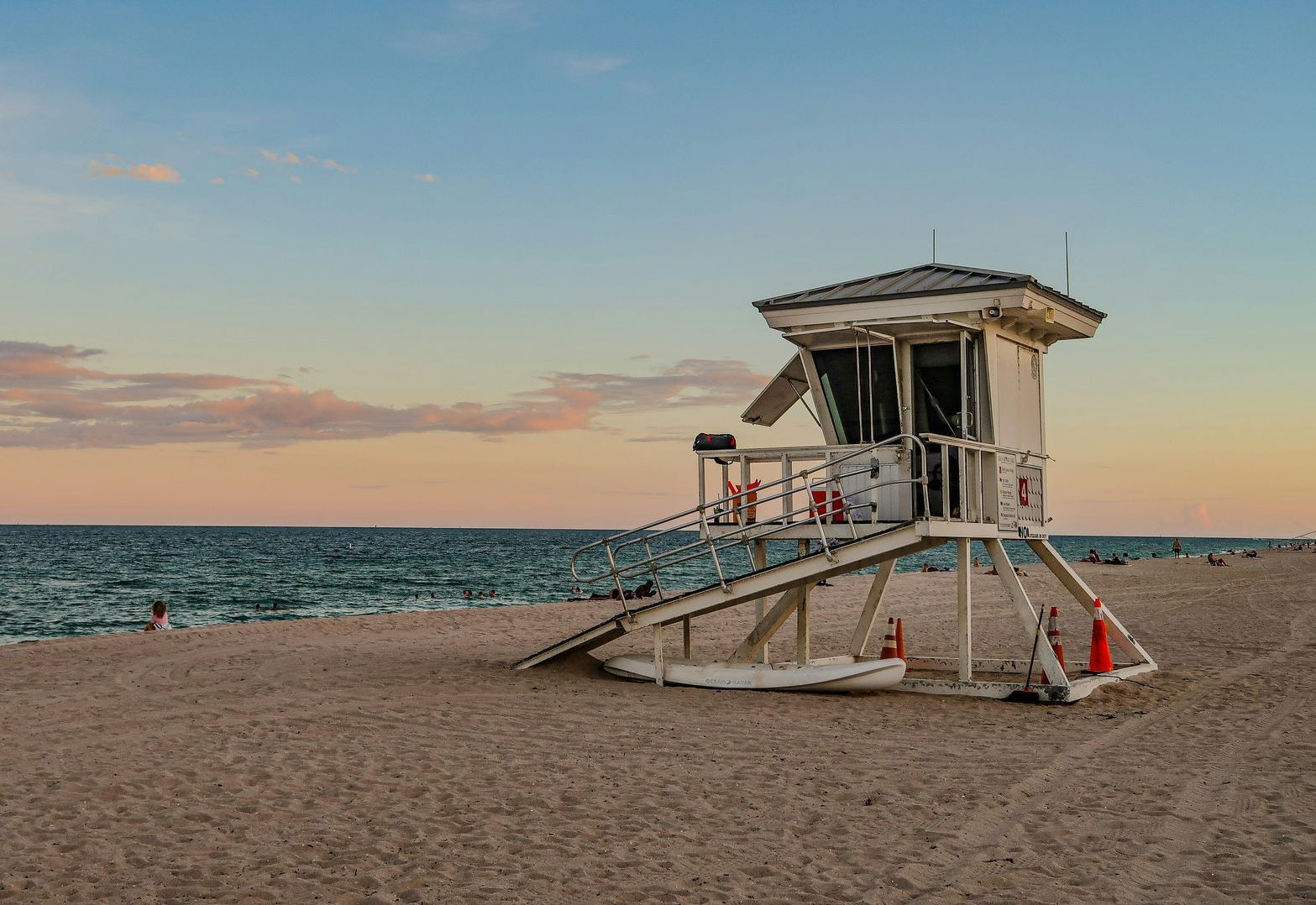 A lifeguard tower is sitting on the beach near the ocean.