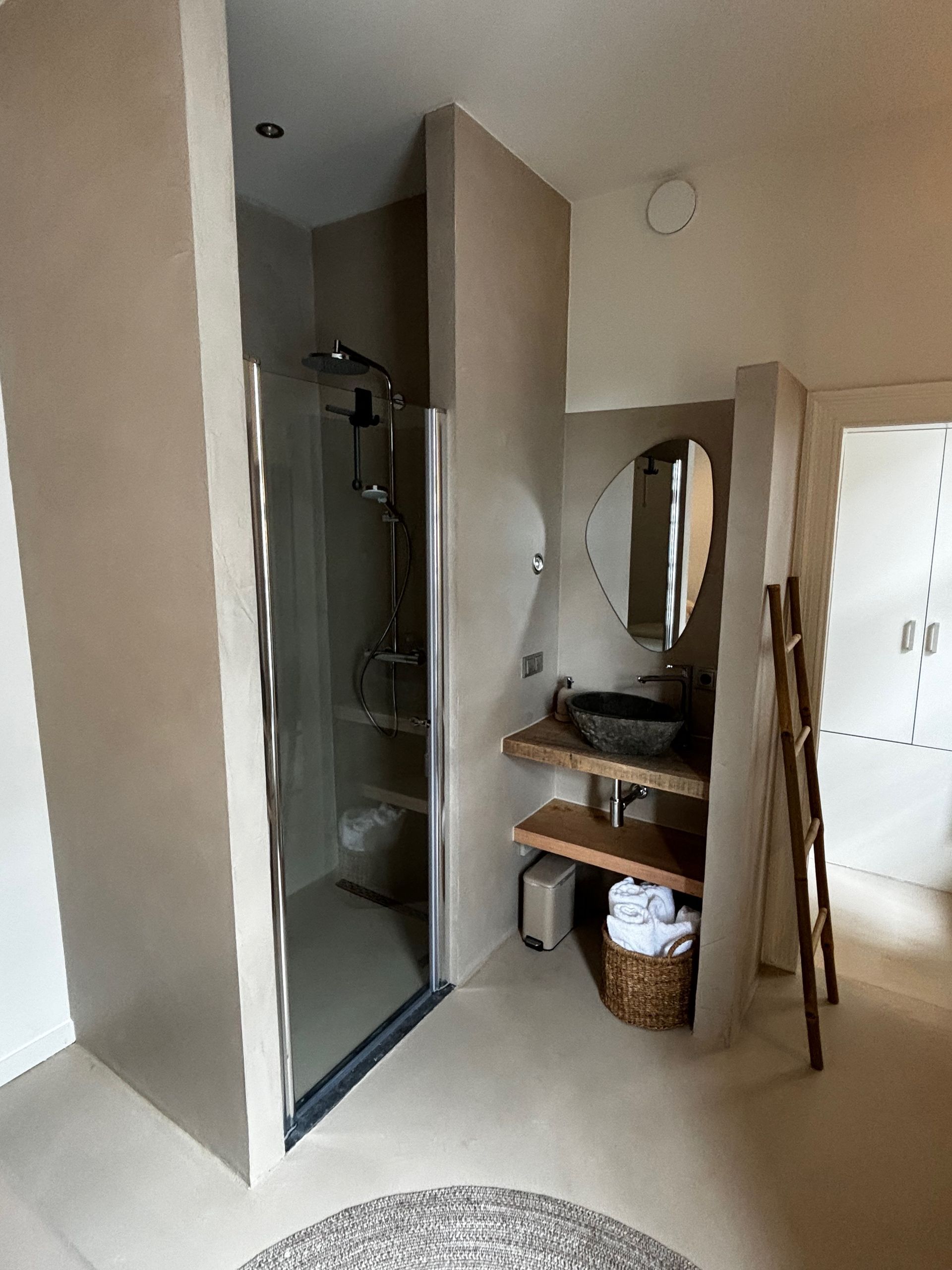 Een badkamer met wastafel en inloopdouche