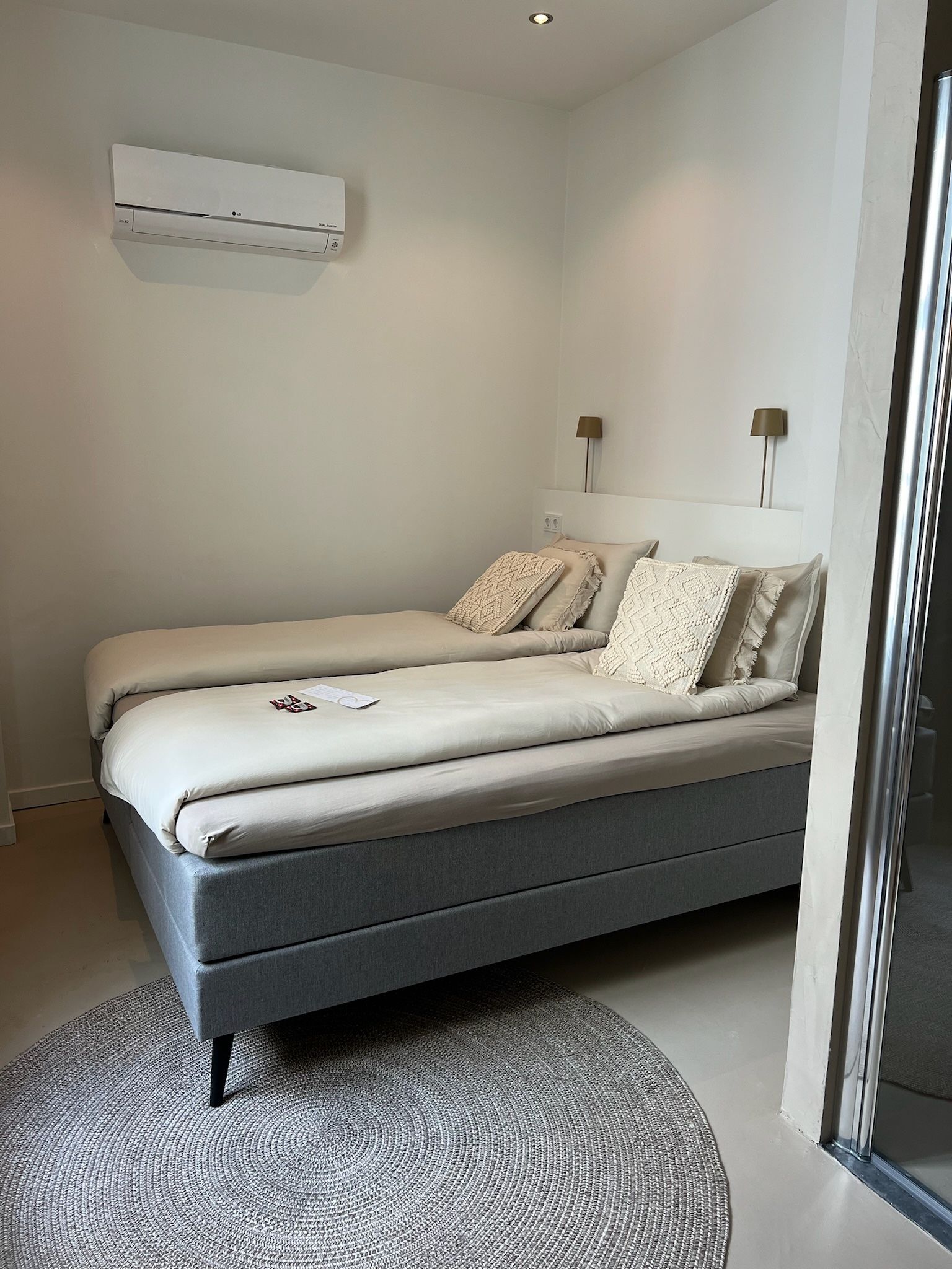 Een slaapkamer met twee bedden en een vloerkleed.