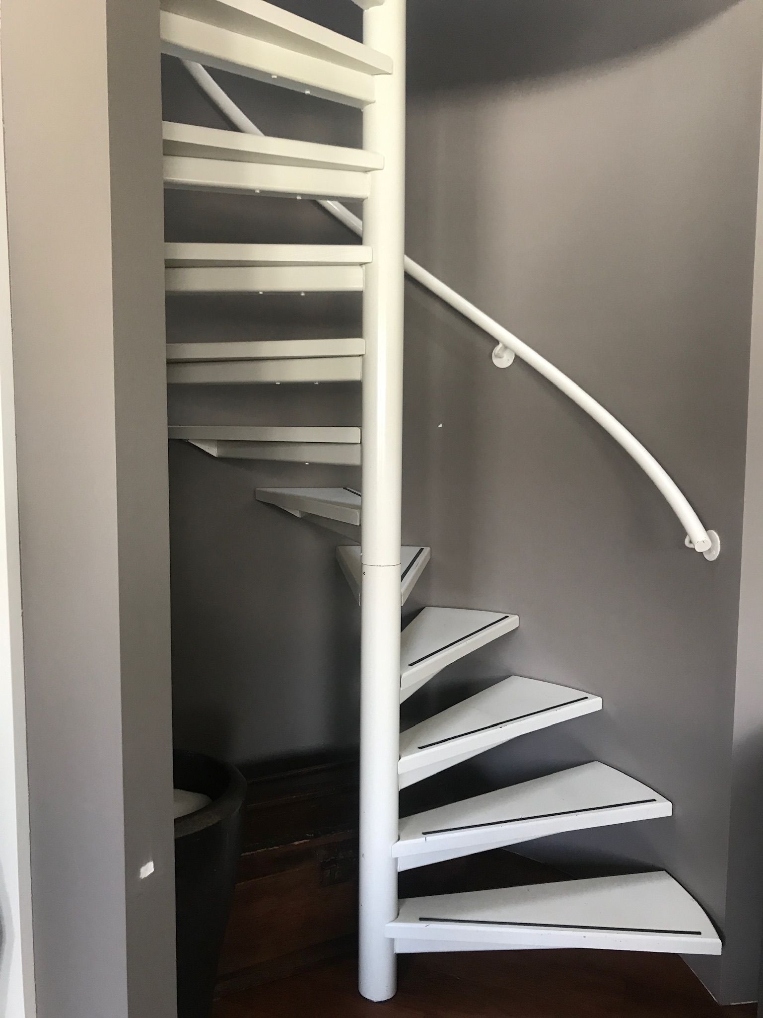 Een wenteltrap met witte treden en een witte balustrade