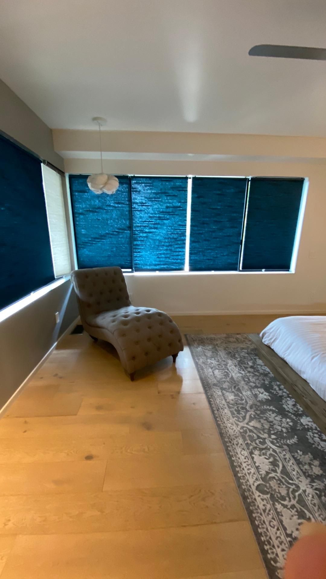 There is a chair in the middle of the room next to a window.