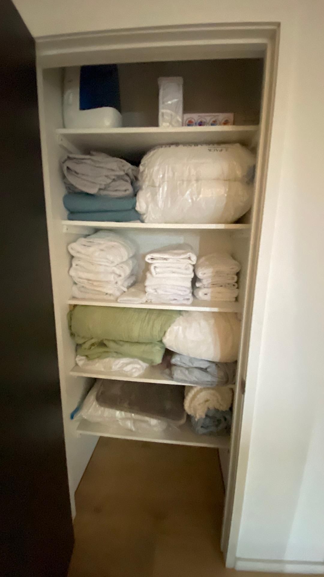 A closet filled with lots of towels and blankets.