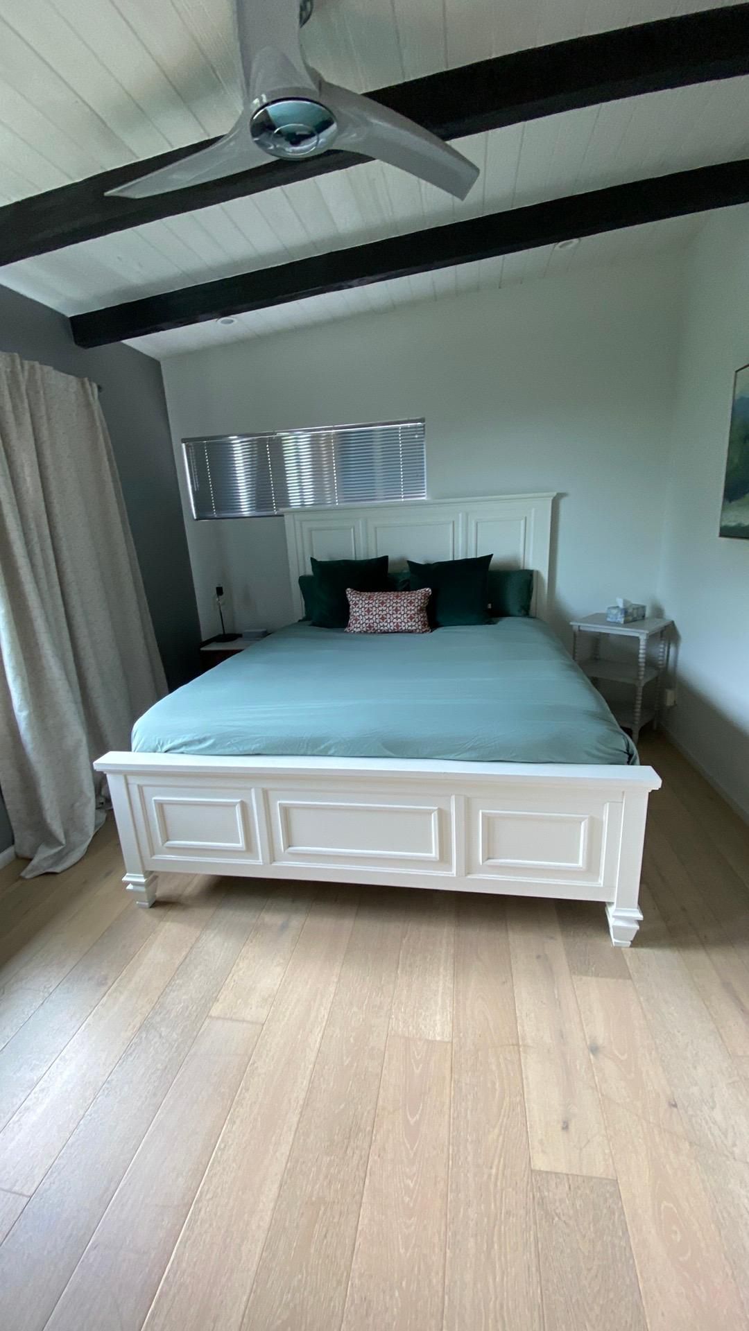 A bedroom with a bed and a ceiling fan.