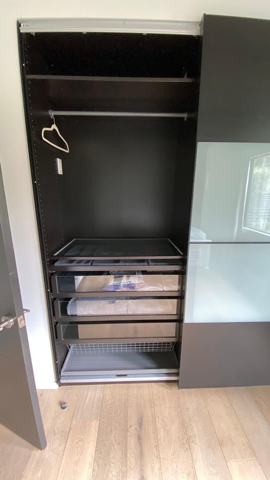 A closet with sliding glass doors and shelves in a room.