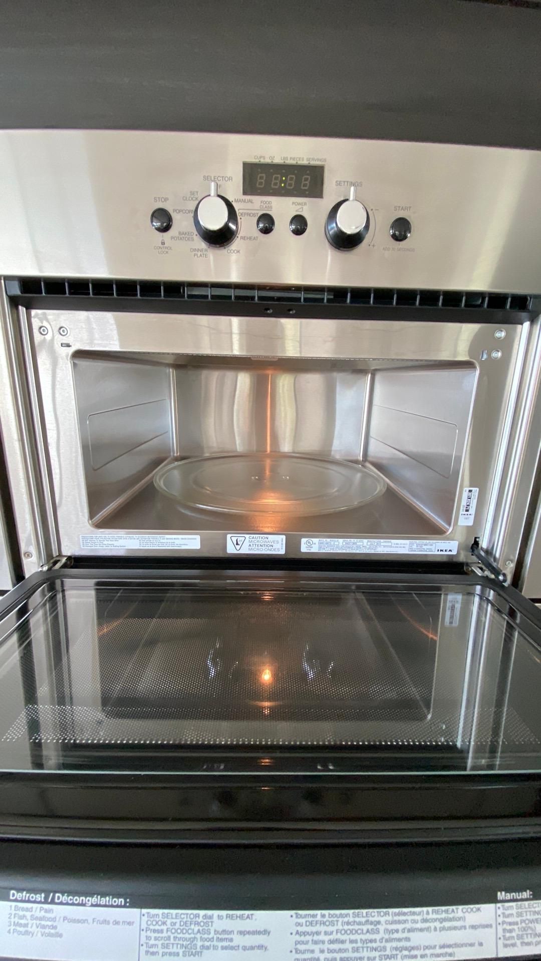 A microwave oven with the door open and a plate in it.