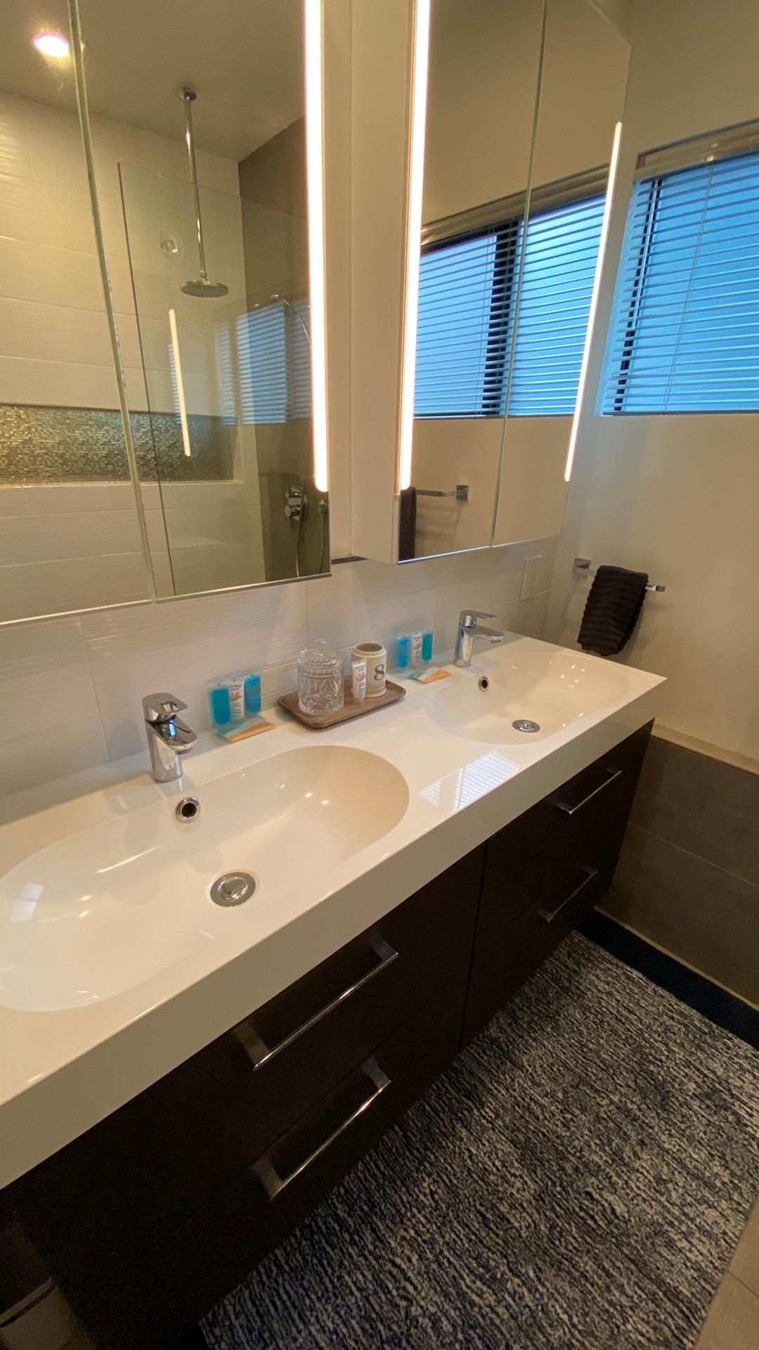 A bathroom with two sinks and a mirror.