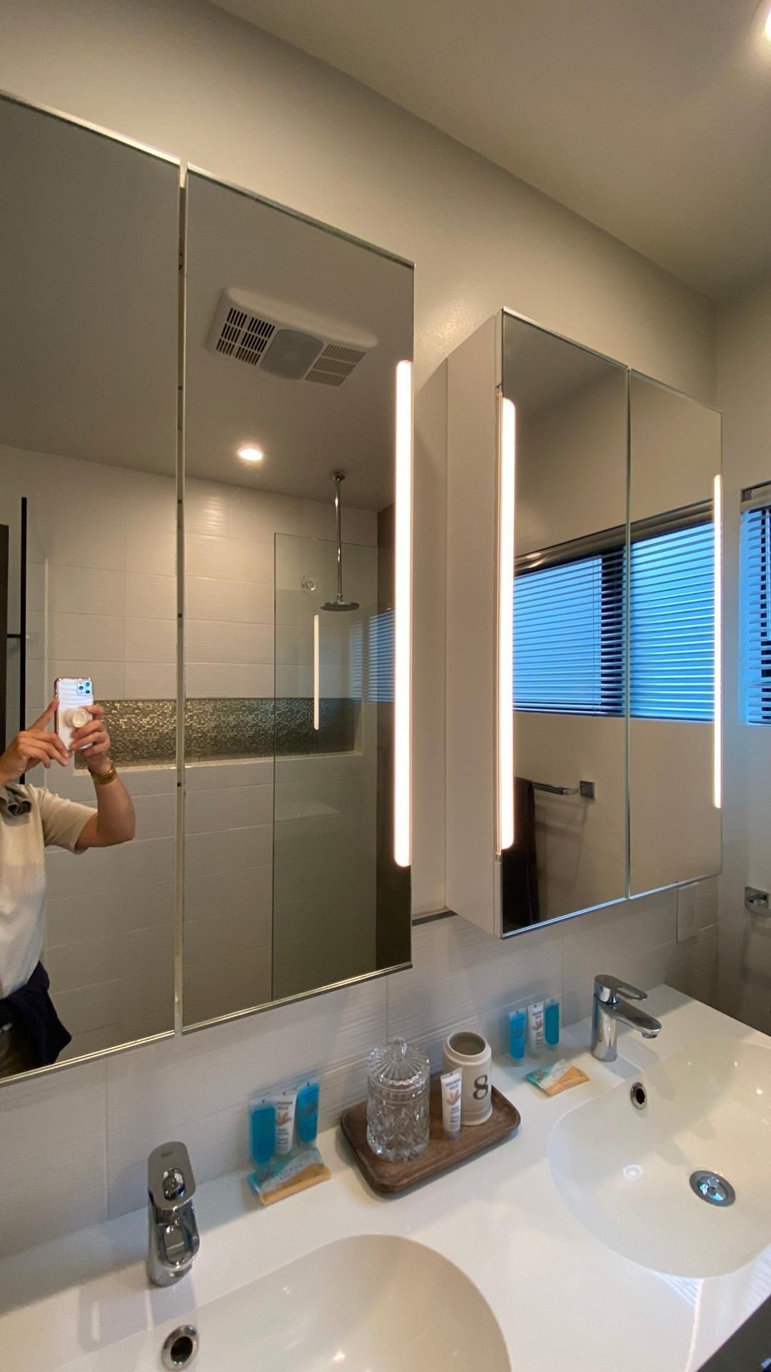 A woman is taking a picture of herself in a bathroom mirror.