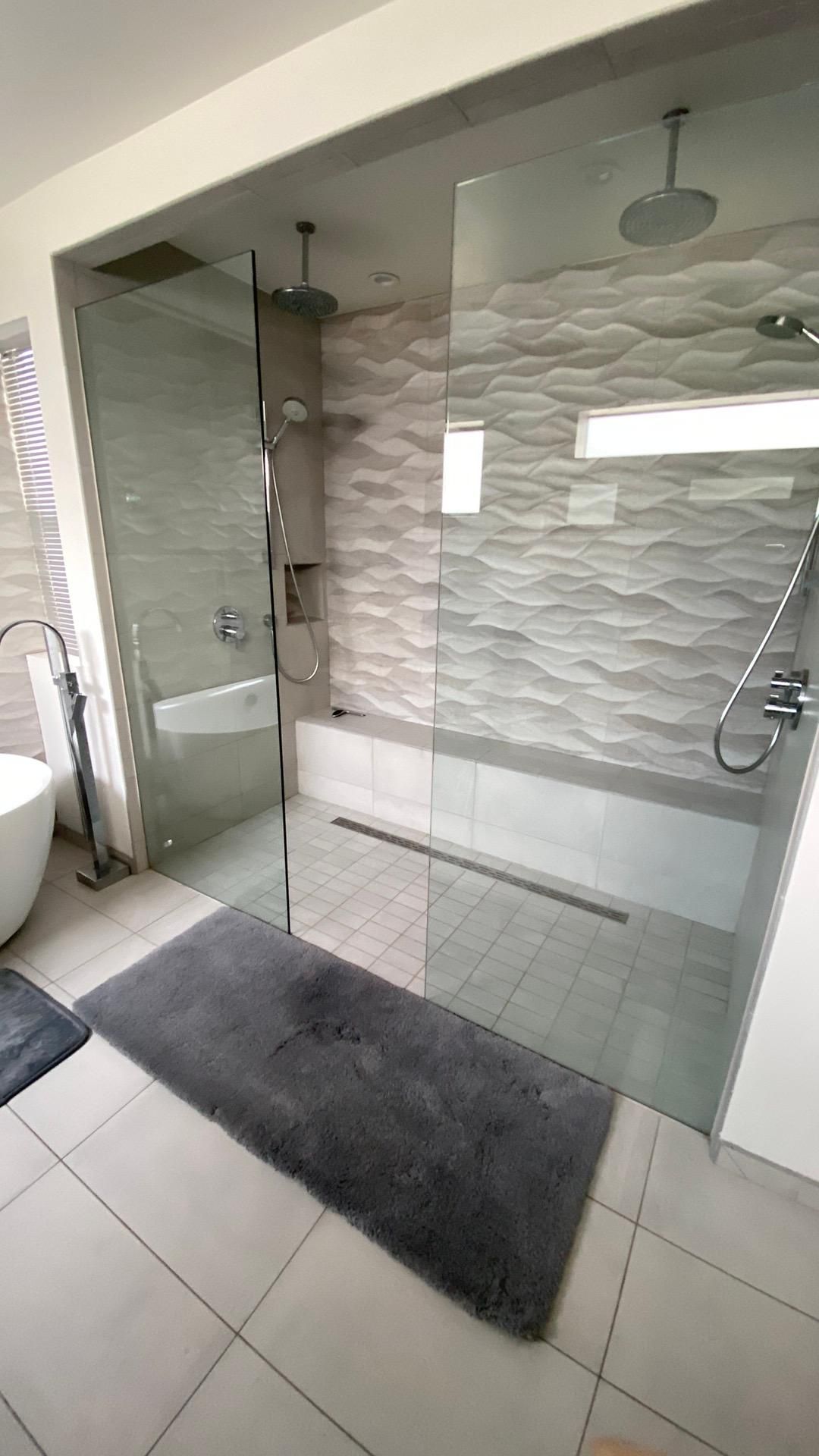 A bathroom with a walk in shower and a bathtub.