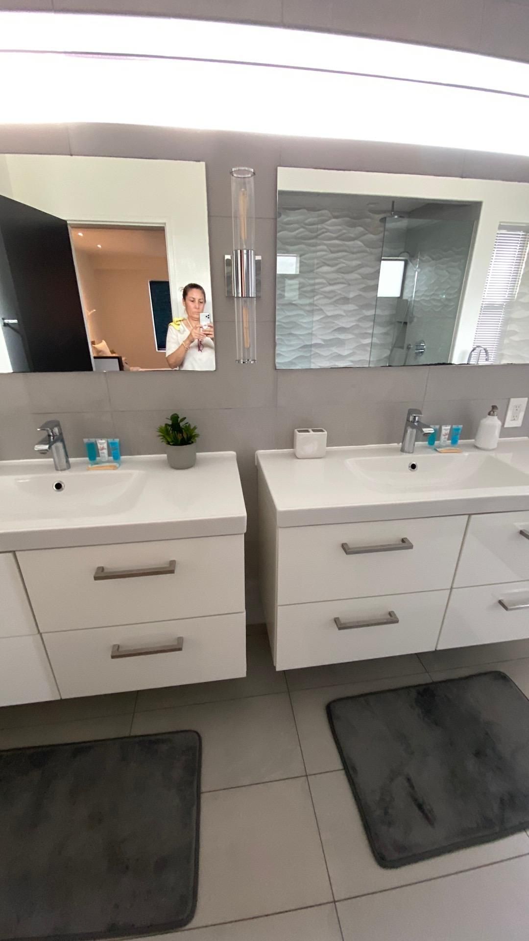 A bathroom with two sinks and two mirrors.