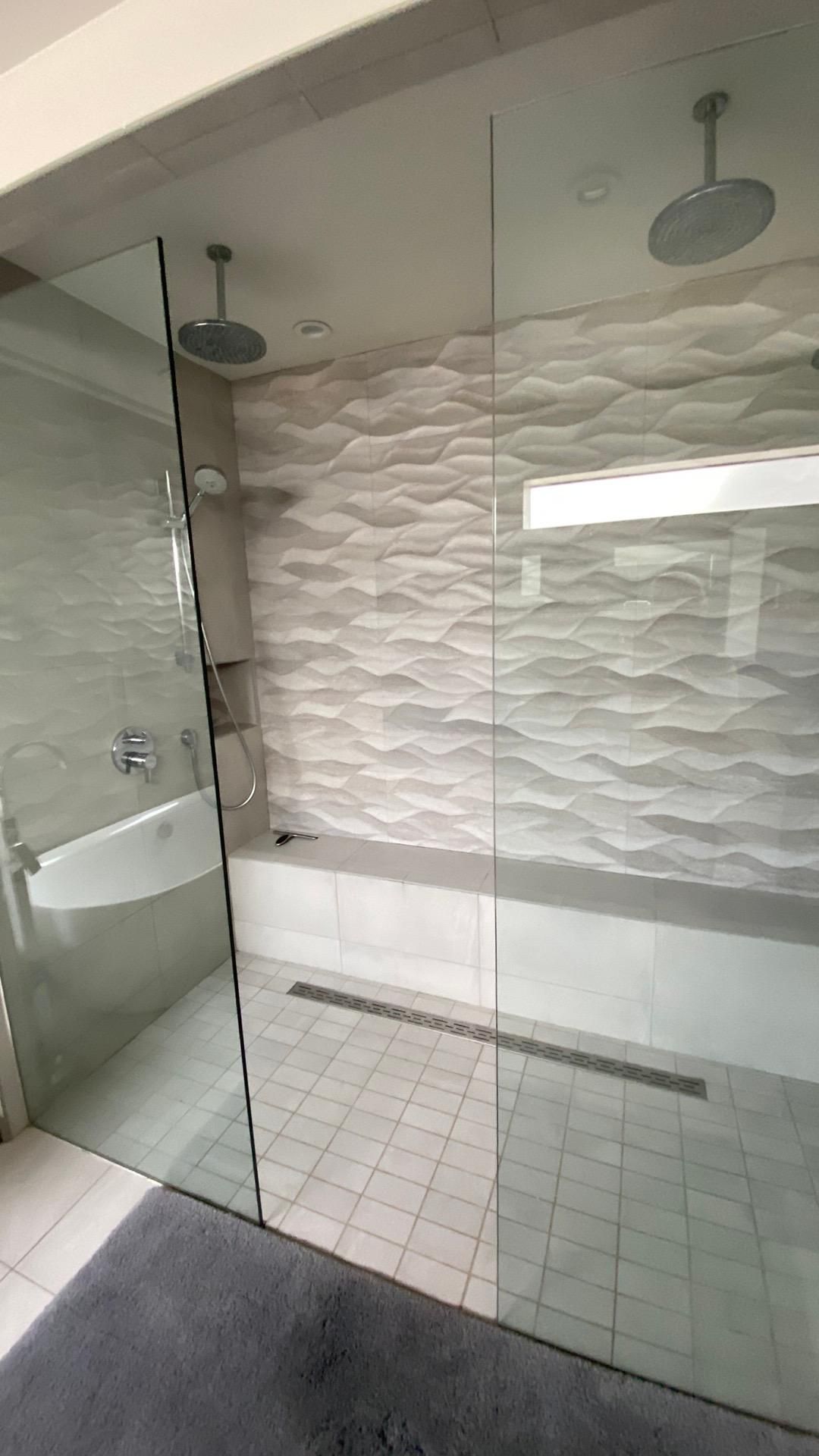 A bathroom with a walk in shower and a bathtub.