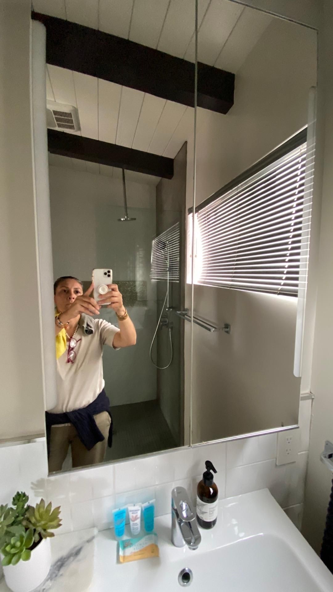 A man is taking a selfie in a bathroom mirror.