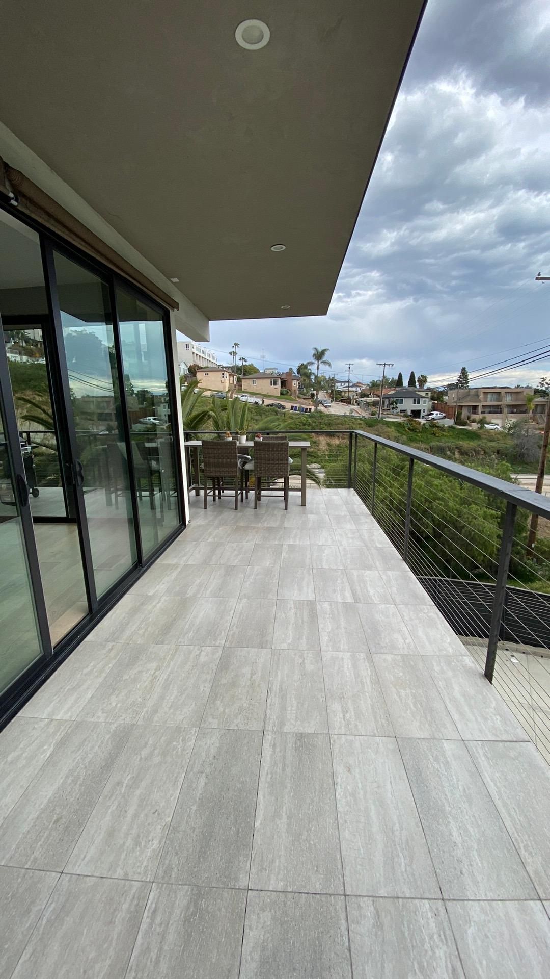 There is a balcony with a table and chairs on it.