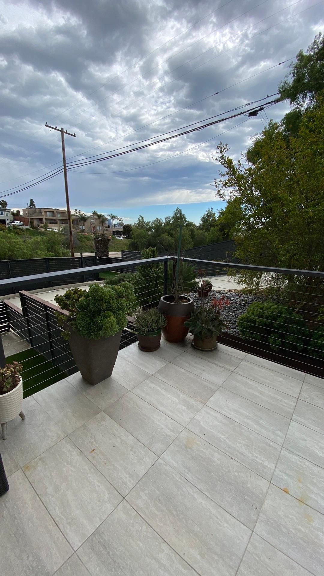 A balcony with potted plants and a view of a city.