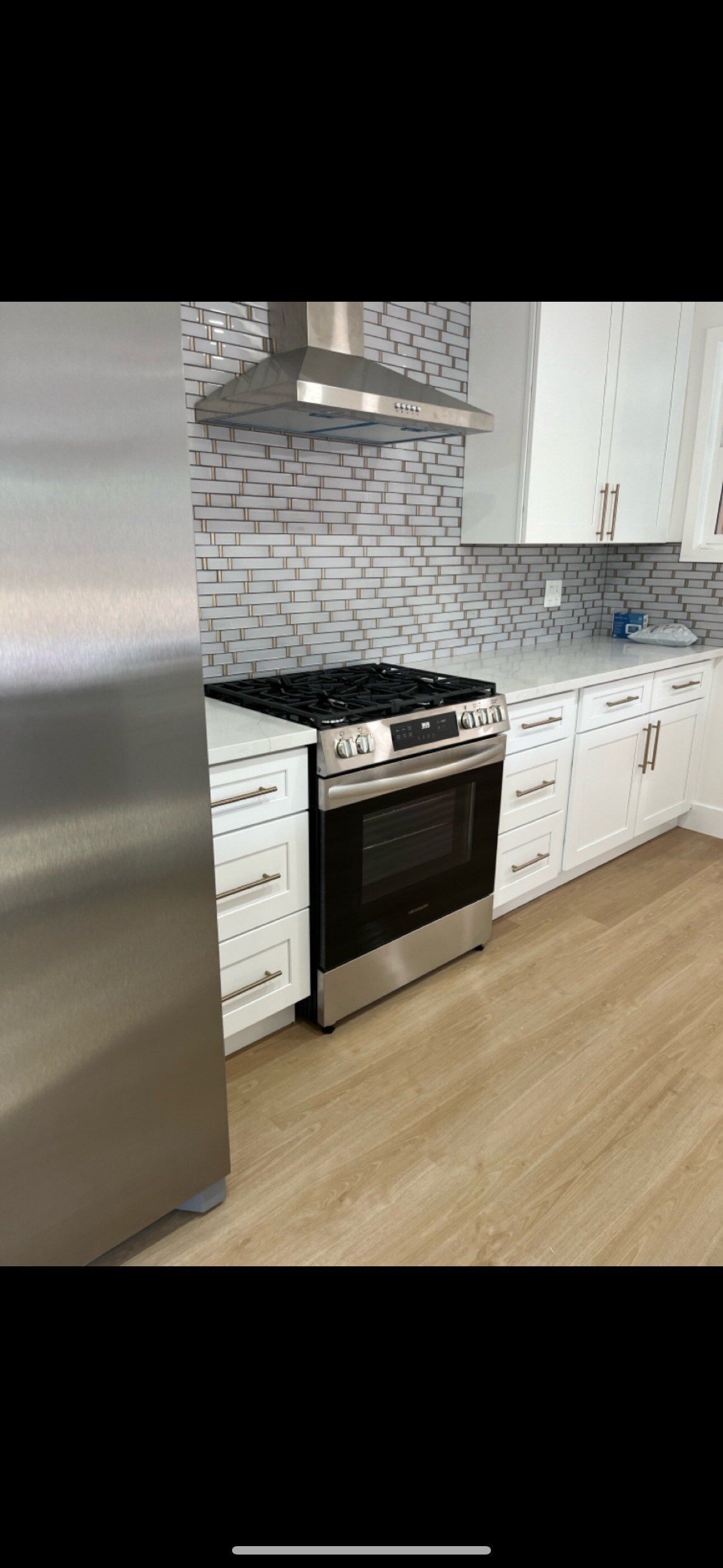 A kitchen with stainless steel appliances and white cabinets.