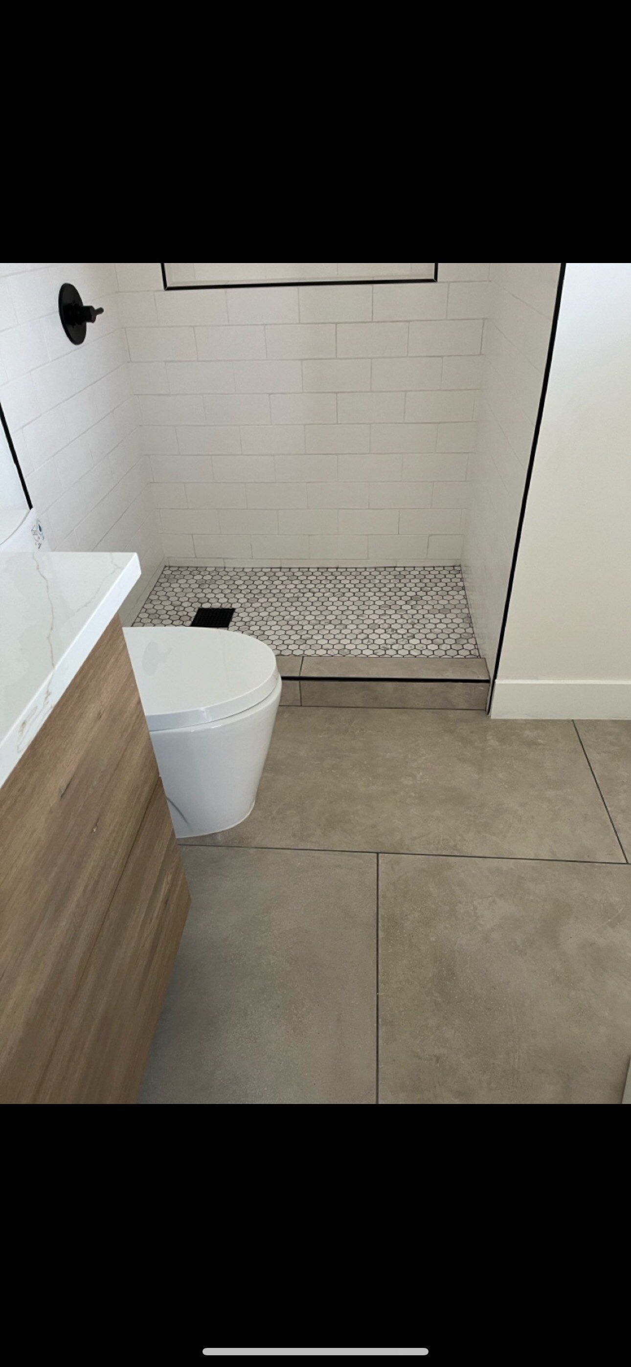 A bathroom with a toilet , sink and shower.