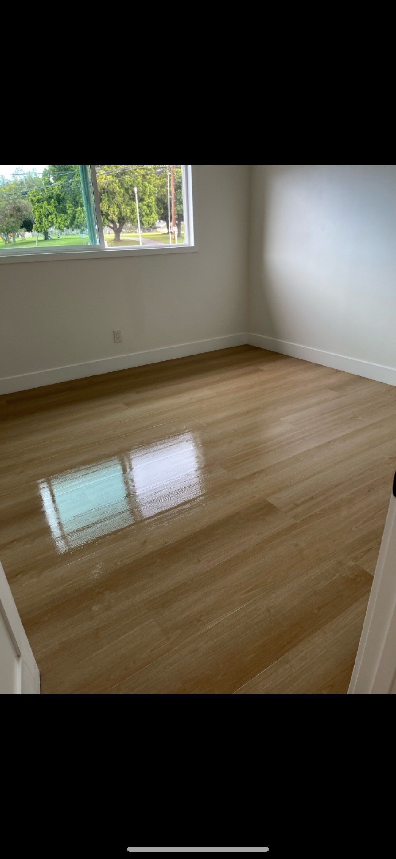 An empty room with a wooden floor and a window.