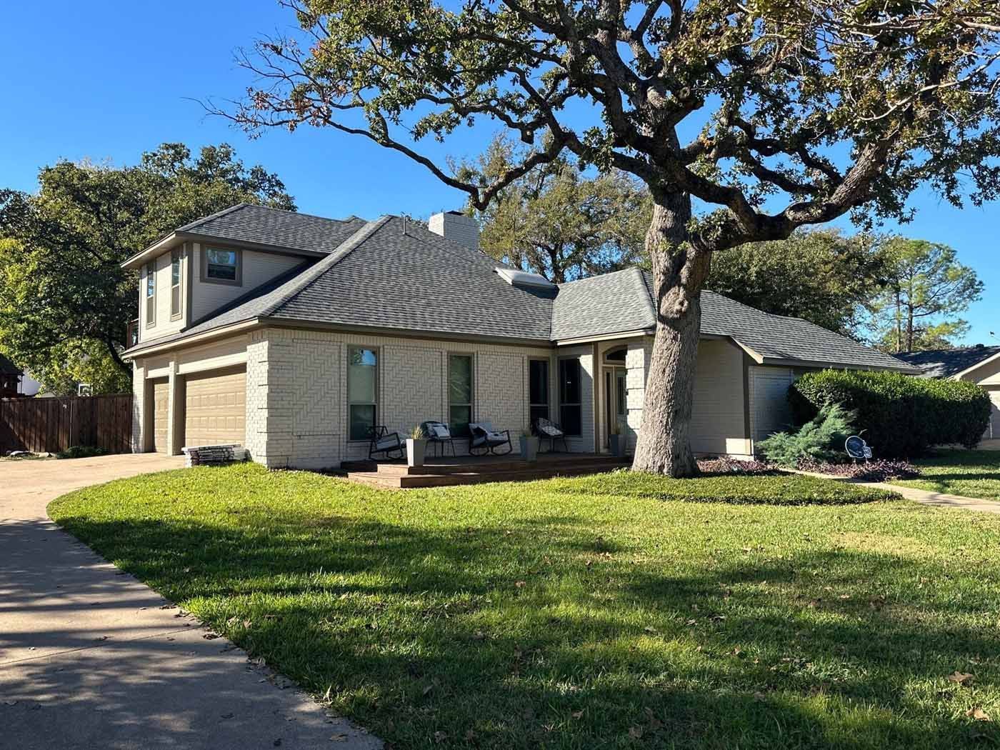A house with a tree in front of it on a sunny day