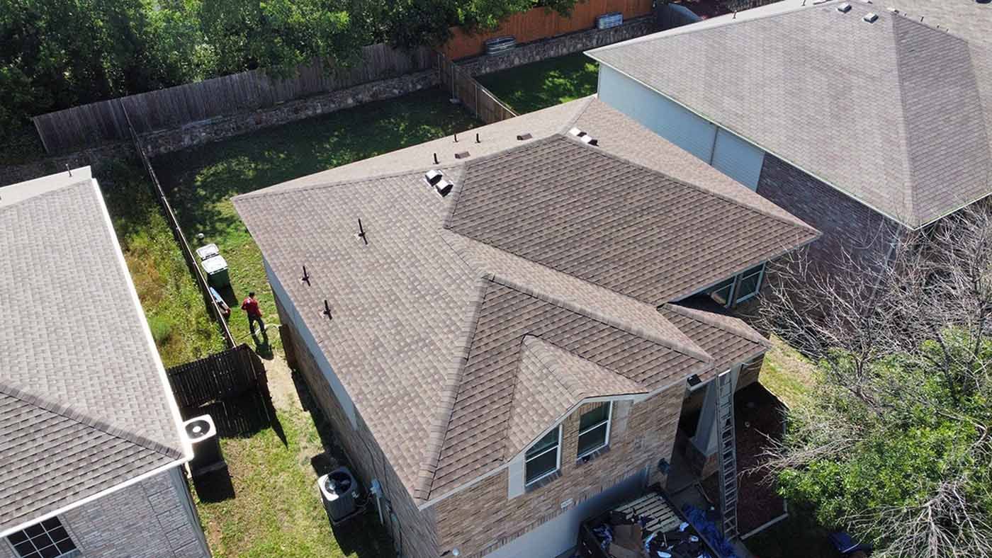 An aerial view of a house with a roof that has been installed.