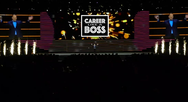 A man is standing on a stage with a sign that says career boss