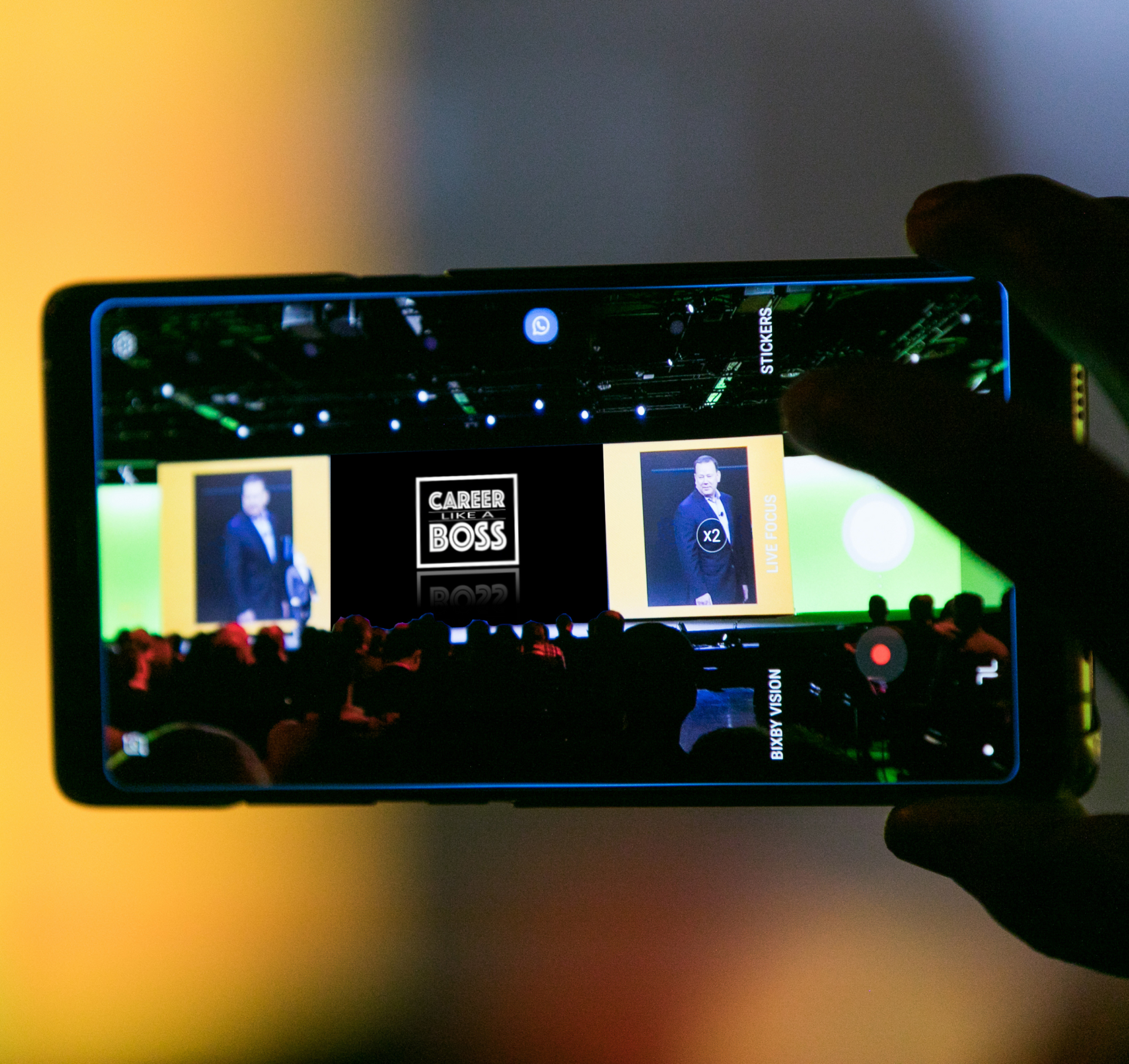 A person is holding a cell phone up to a stage that says career box