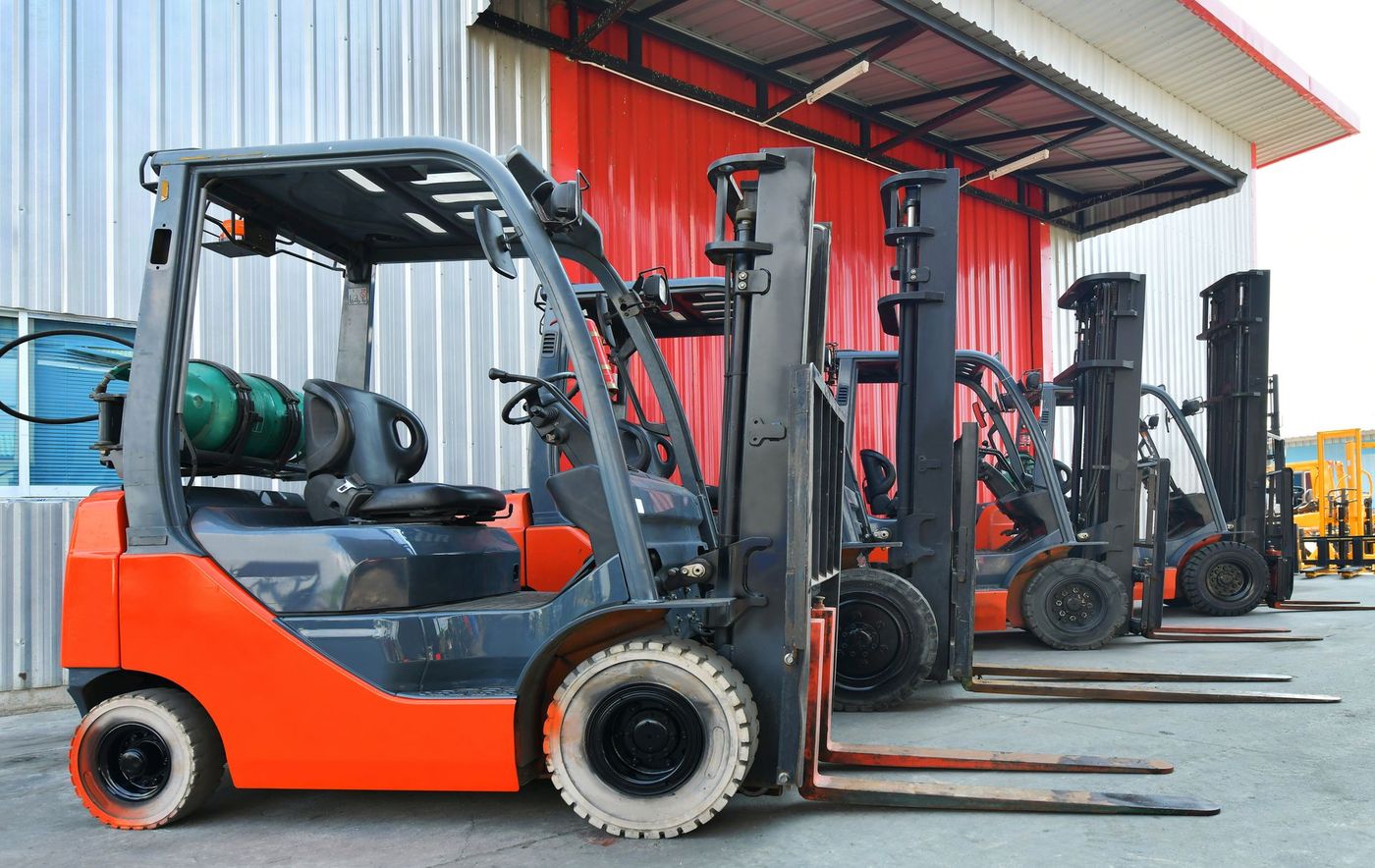 A Row of Forklifts Are Parked in Front of a Building | Shepperton, VIC | L&P Mackin Forklifts
