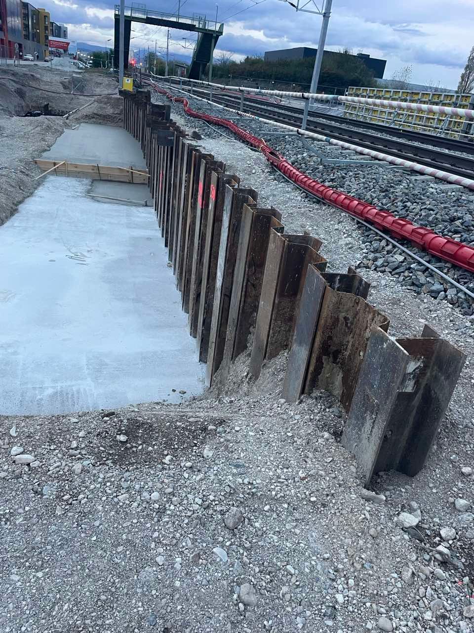 ein Metallzaun auf einer Baustelle mit Autos dahinter .