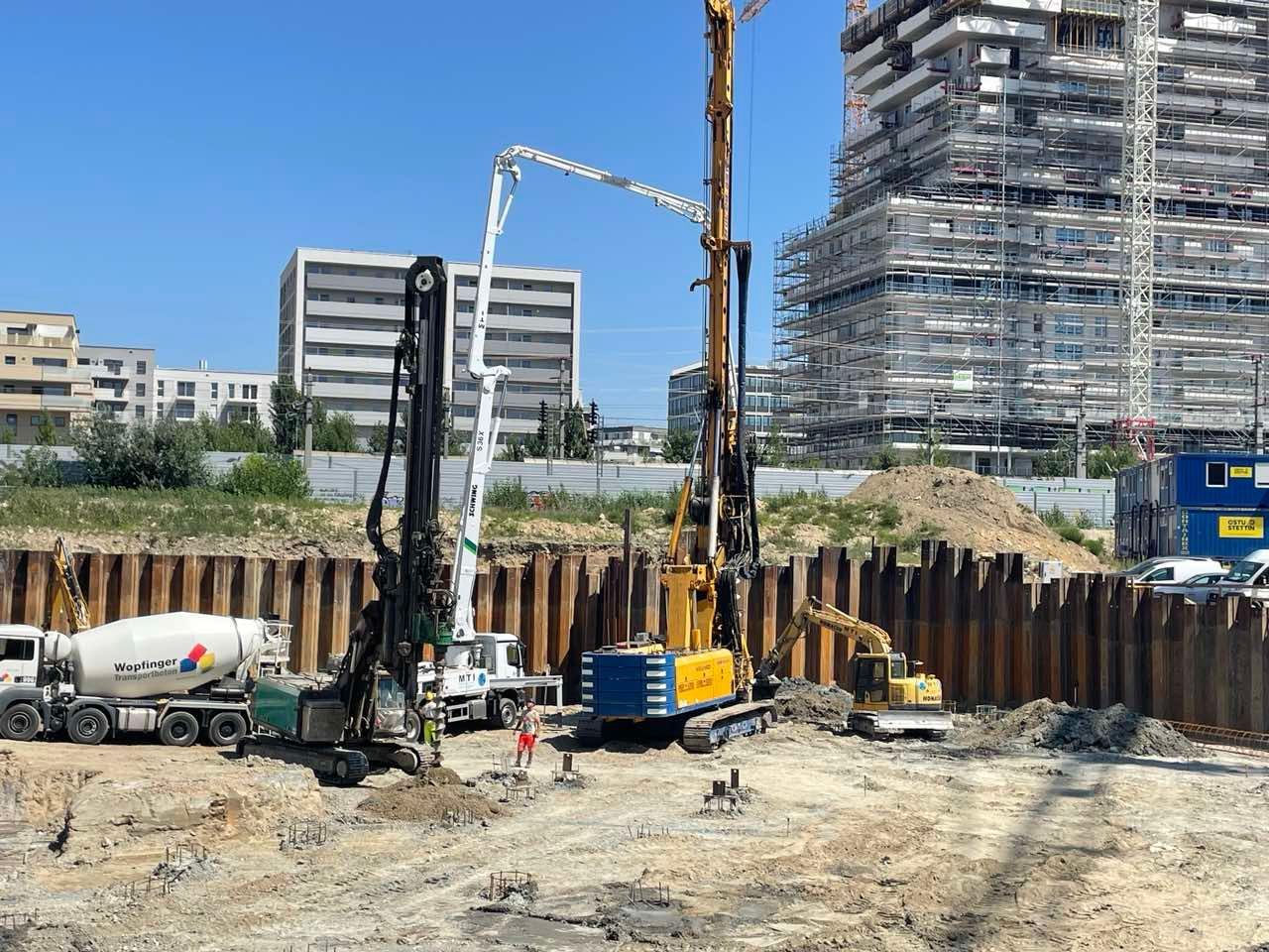 ein Betonmischer auf einer Baustelle steht neben einem Traktor