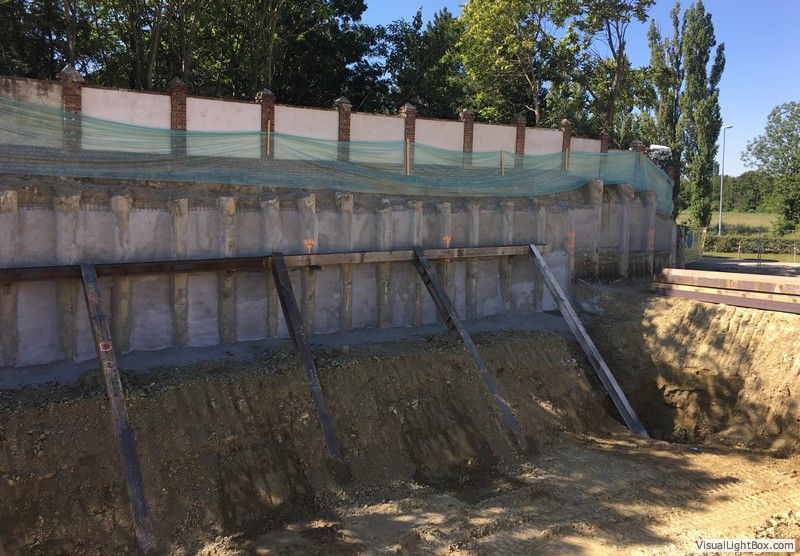 eine Baustelle mit einer Wand und einem Graben davor .