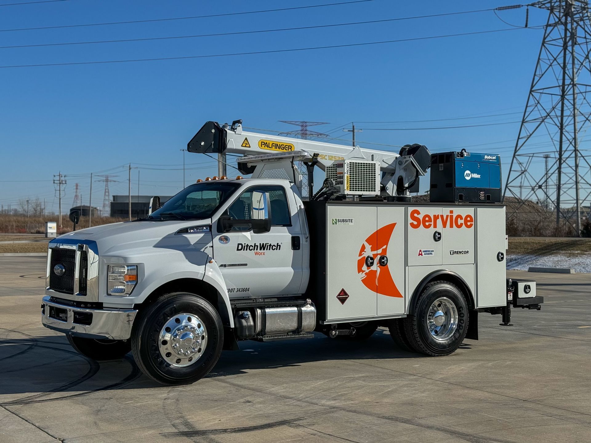 White service truck with a crane on a bright day.