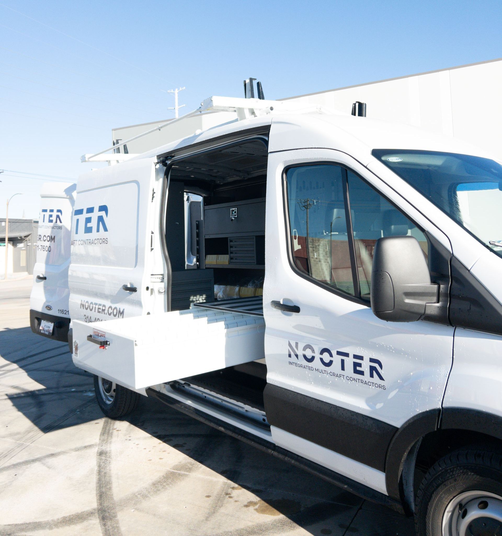 White van with open side door, labeled "NOCTER" for service.