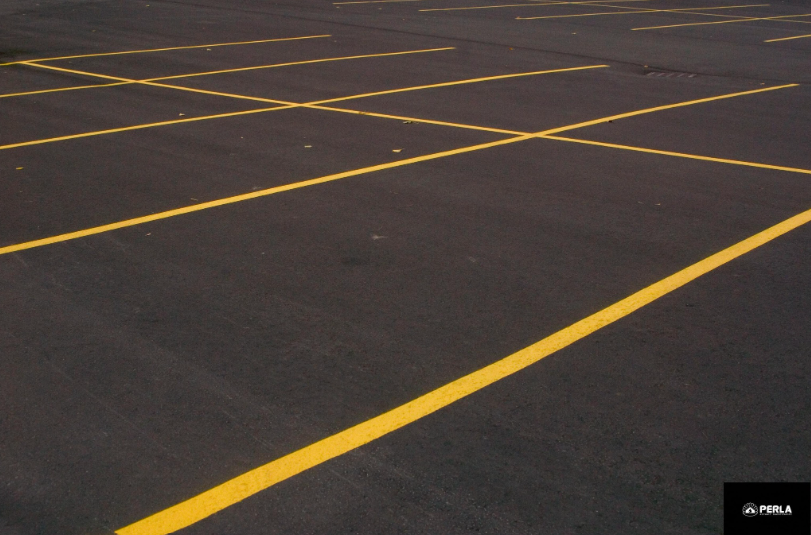 Yellow parking space lines on black asphalt.