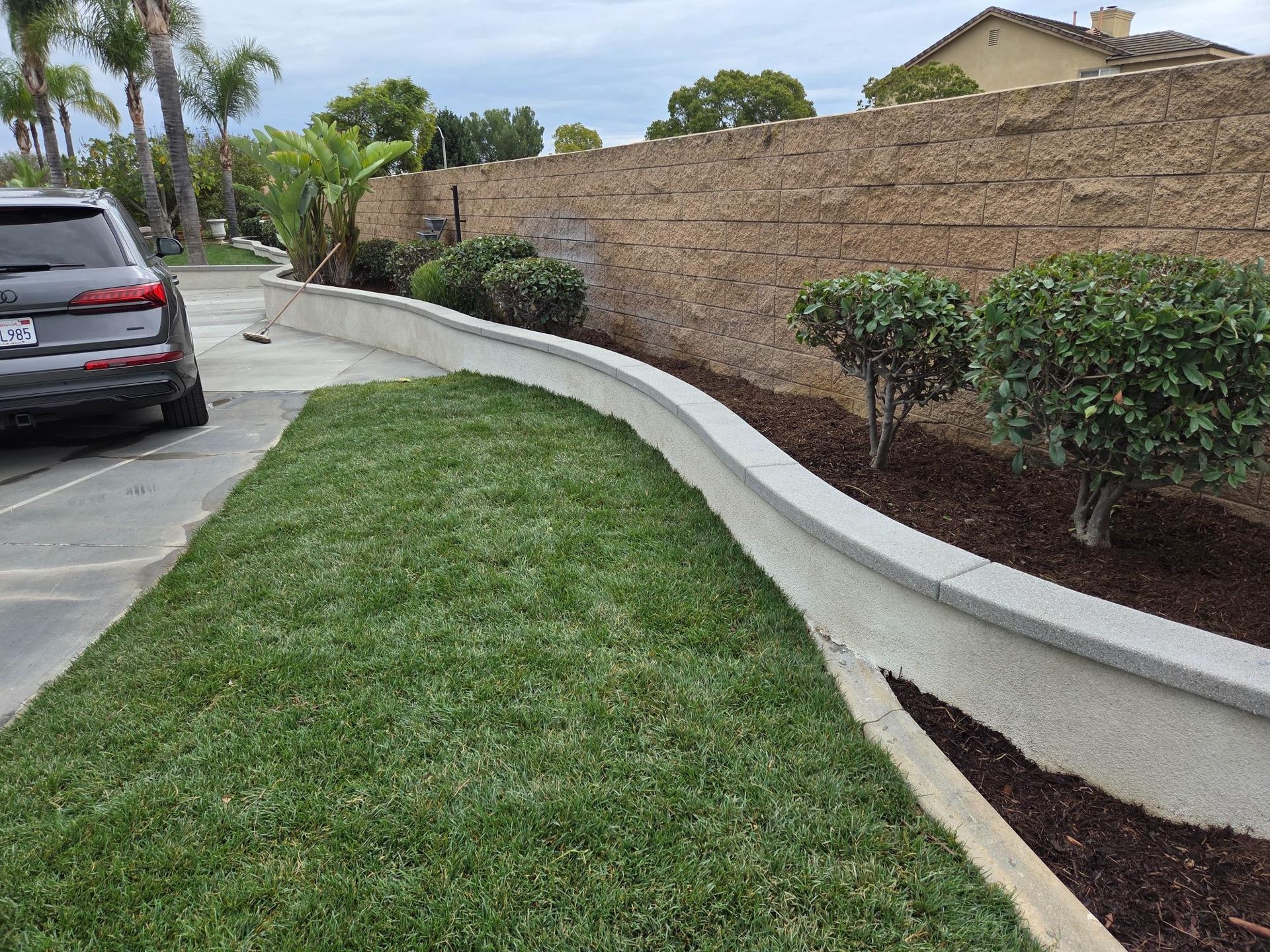 Front yard with house, lawn, rock landscaping, and a wooden fence.