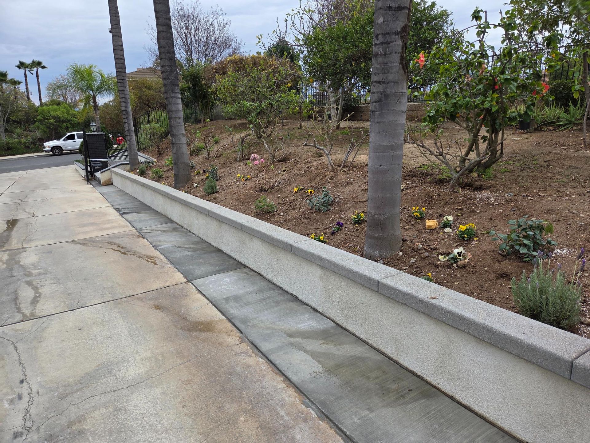Concrete curb and gutter along driveway with landscaping on a slight slope.