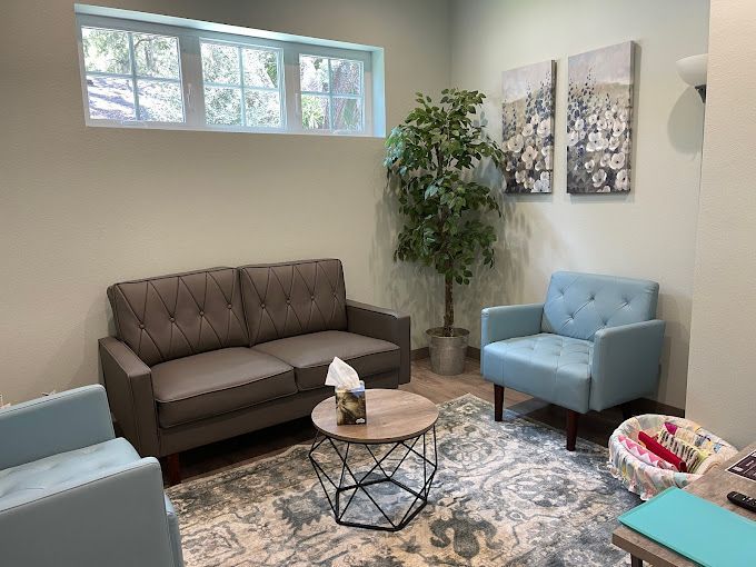 A living room with a couch , chairs , and a table.