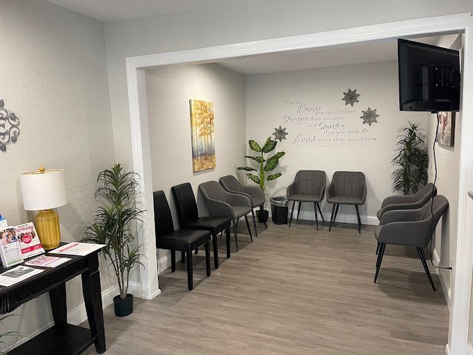 A waiting room with a lot of chairs and a television.