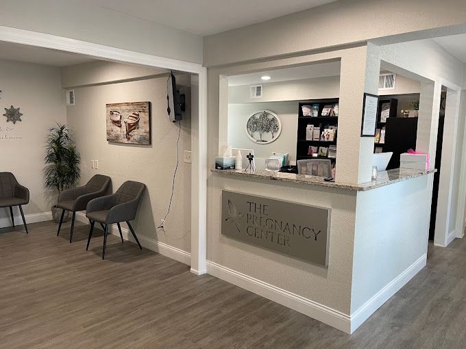 A waiting room with chairs and a counter in a medical office.