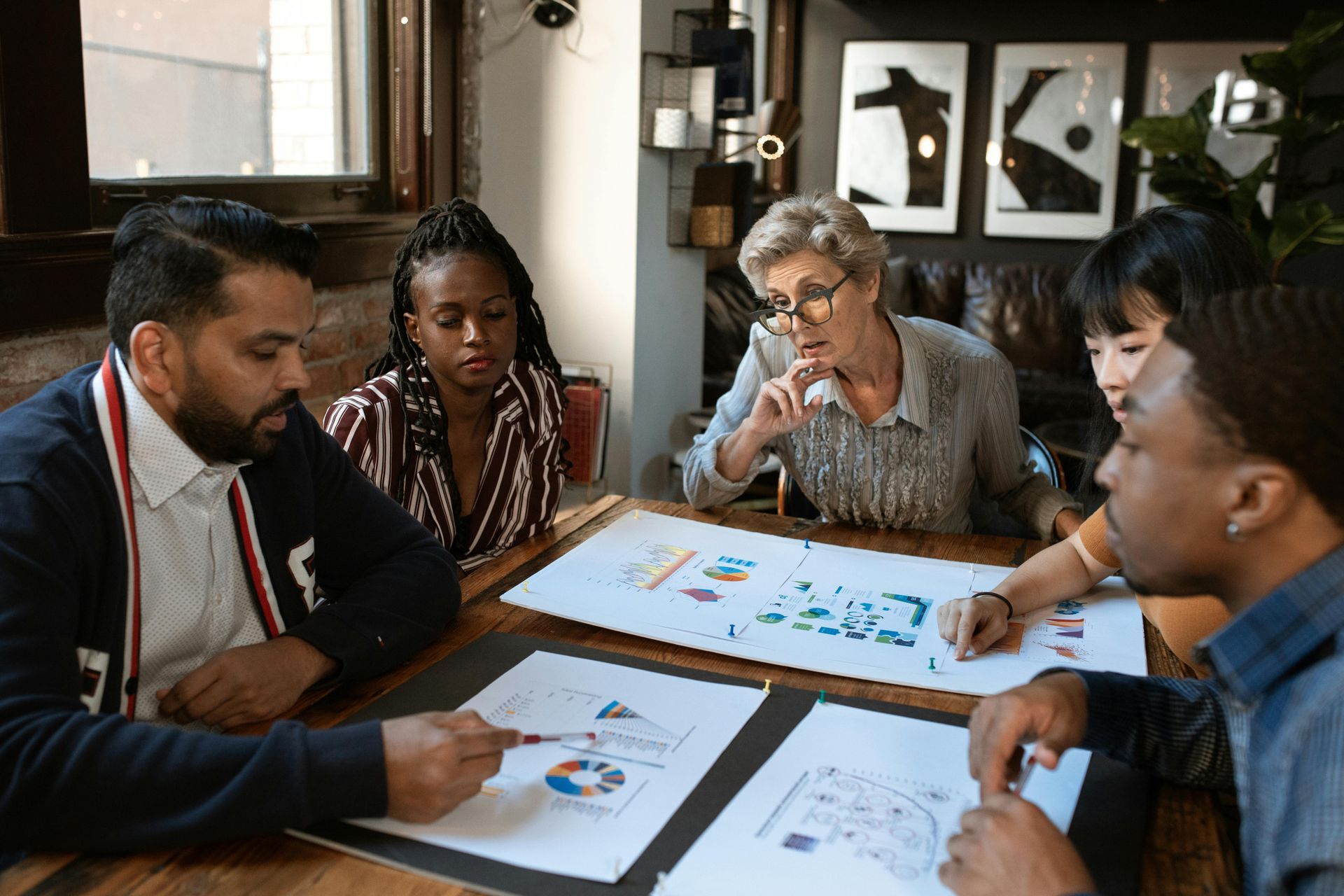 A group of people are sitting around a table looking at papers.