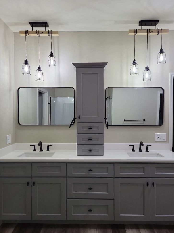 A man is standing in a kitchen working on a sink.