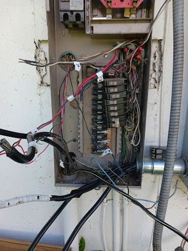 A very messy electrical box with a lot of wires coming out of it.
