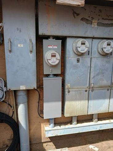 A bunch of electrical boxes and meters on the side of a building.