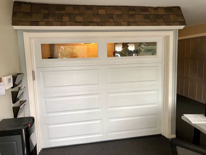 A wooden garage door with blue trim and windows