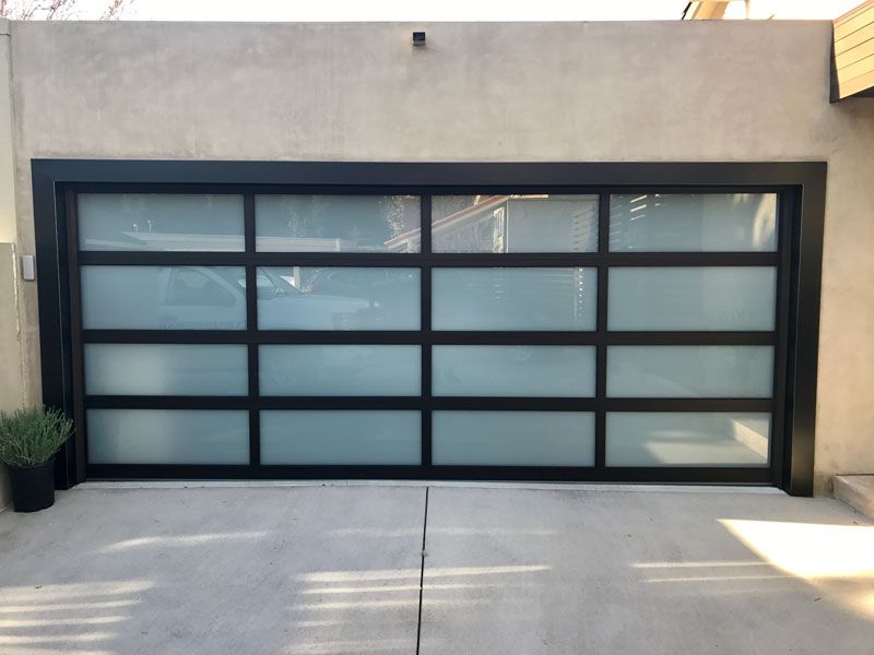 A wooden garage door with blue trim and windows